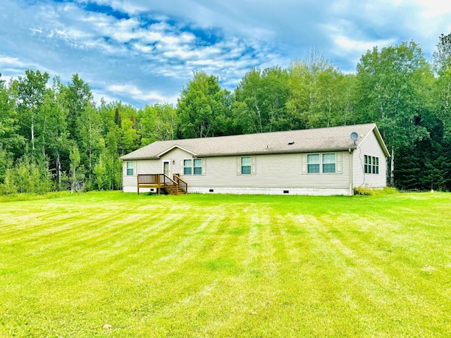 rear view of property featuring a wooden deck and a lawn