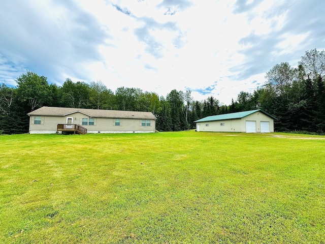 view of yard with a garage, an outdoor structure, and a wooden deck