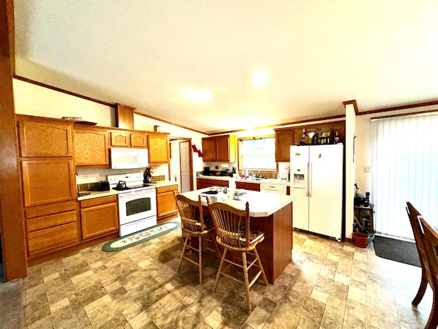 kitchen featuring ornamental molding, a center island with sink, a kitchen bar, vaulted ceiling, and white appliances