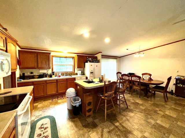 kitchen with sink, a textured ceiling, white appliances, a center island, and pendant lighting