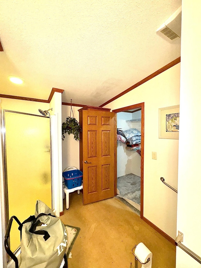 corridor with lofted ceiling, a textured ceiling, and crown molding