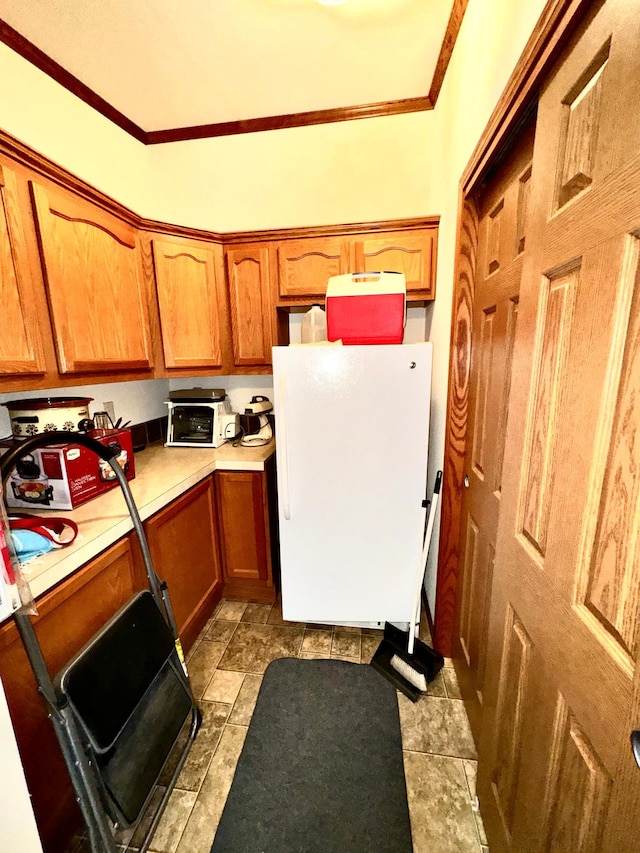 50370 Turtle River Rd, Marcell, MN 56628 - kitchen with freestanding refrigerator, ornamental molding, light countertops, and brown cabinetry