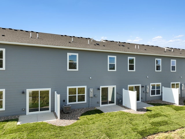 rear view of property with cooling unit, a lawn, and a patio