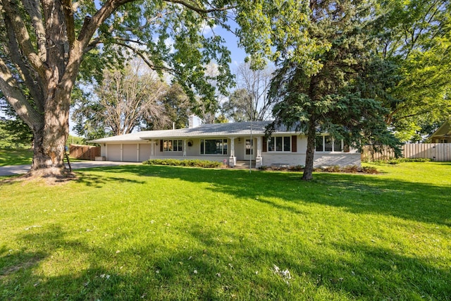 rear view of property featuring a garage and a yard