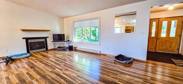 living room with a baseboard heating unit, a healthy amount of sunlight, and dark wood-type flooring