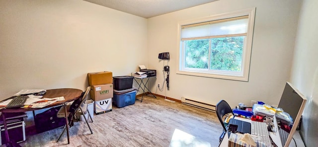 office space featuring baseboard heating and light wood-type flooring