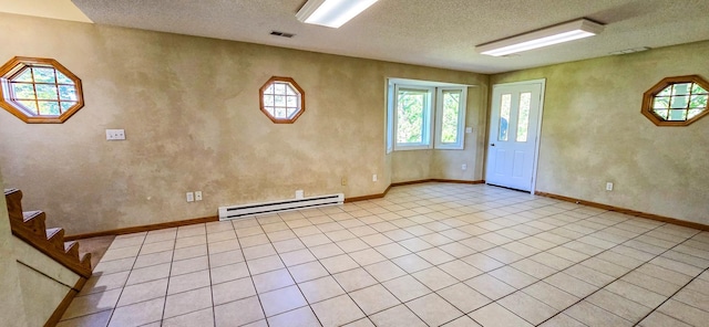 tiled foyer entrance featuring a textured ceiling and baseboard heating