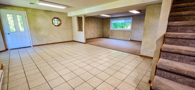 basement with a baseboard heating unit and light tile patterned floors