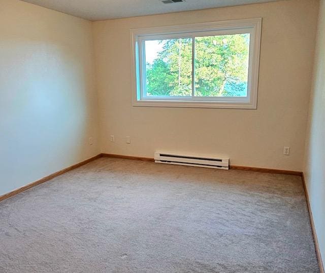 carpeted spare room featuring baseboard heating