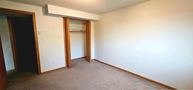 unfurnished bedroom with carpet flooring and a closet