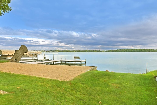 view of dock featuring a water view, a yard, and boat lift