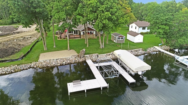 view of dock featuring a yard, a deck with water view, and boat lift