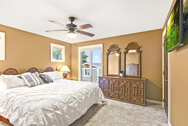 carpeted bedroom with access to outside, a ceiling fan, and baseboards