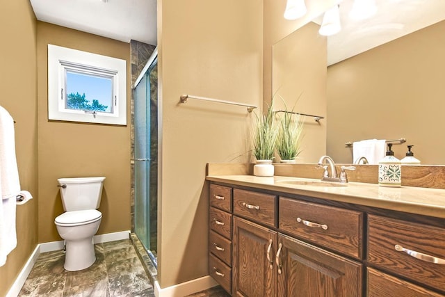 full bath with a shower stall, baseboards, vanity, and toilet