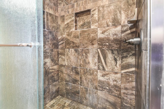 interior details featuring a tile shower