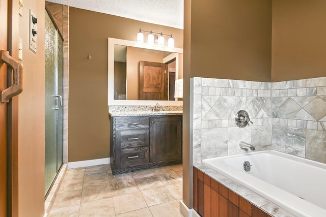 bathroom featuring a textured ceiling, tile patterned flooring, a garden tub, vanity, and a stall shower