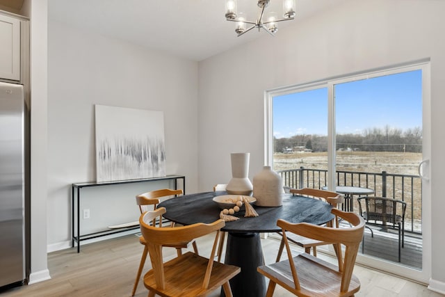 dining room with light hardwood / wood-style flooring and a chandelier