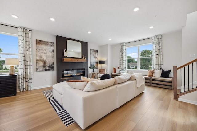 living room with a large fireplace and light wood-type flooring