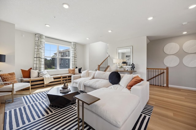 living room with baseboards, light wood-type flooring, and recessed lighting