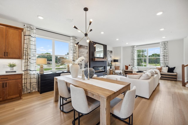 dining room with plenty of natural light, a large fireplace, and light hardwood / wood-style floors