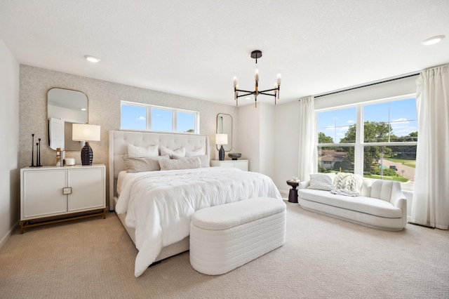 carpeted bedroom with an inviting chandelier and a textured ceiling