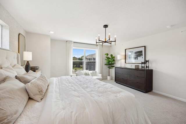 bedroom with a textured ceiling, an inviting chandelier, and light carpet