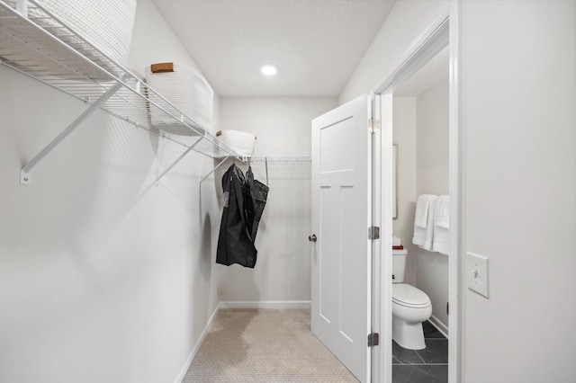 spacious closet with light tile patterned floors