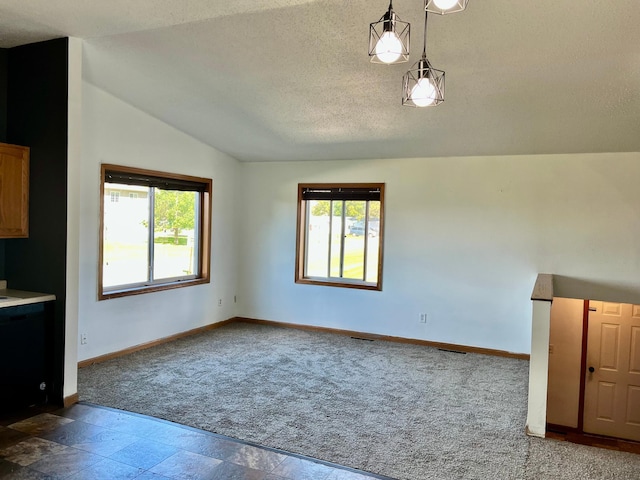 unfurnished living room with vaulted ceiling, a textured ceiling, and carpet flooring