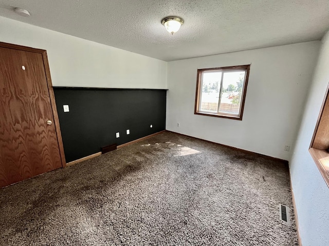 carpeted spare room with a textured ceiling