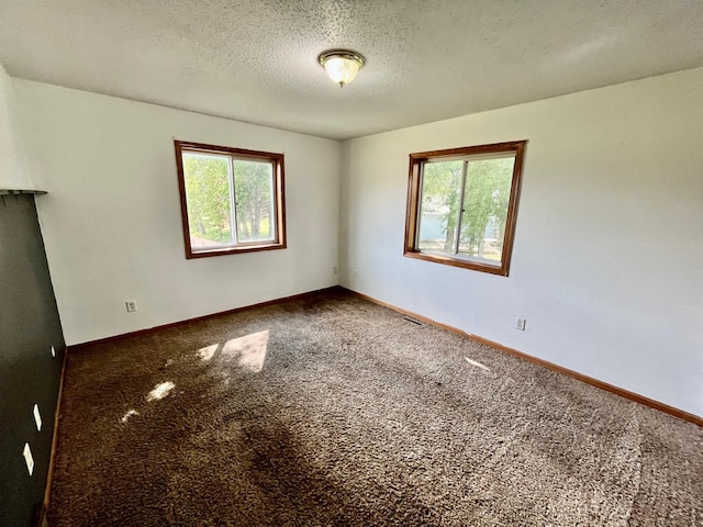 carpeted spare room featuring a textured ceiling