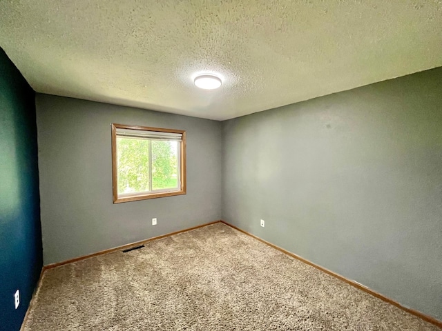 empty room with a textured ceiling and carpet floors