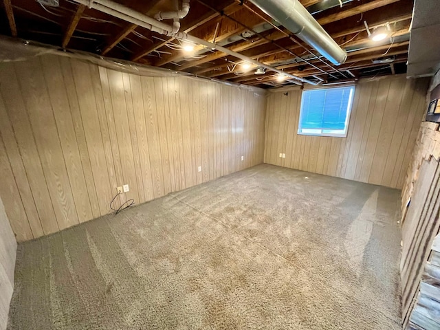 basement featuring carpet floors and wooden walls