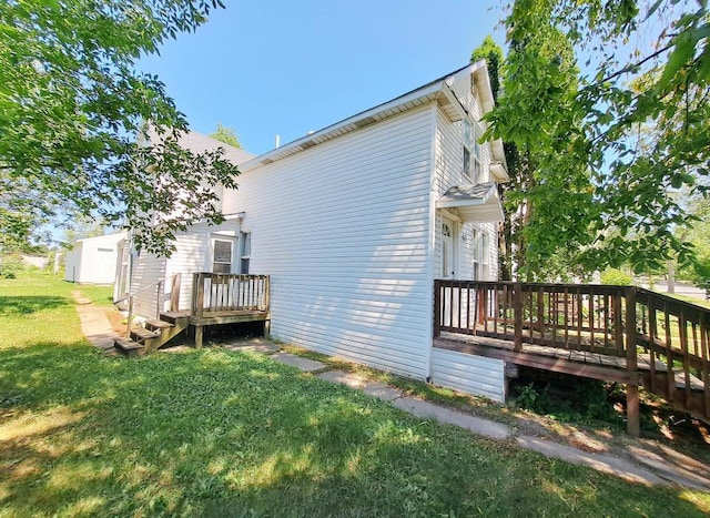 view of side of home with a wooden deck and a yard