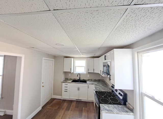 kitchen with dark hardwood / wood-style flooring, stainless steel appliances, white cabinetry, and sink