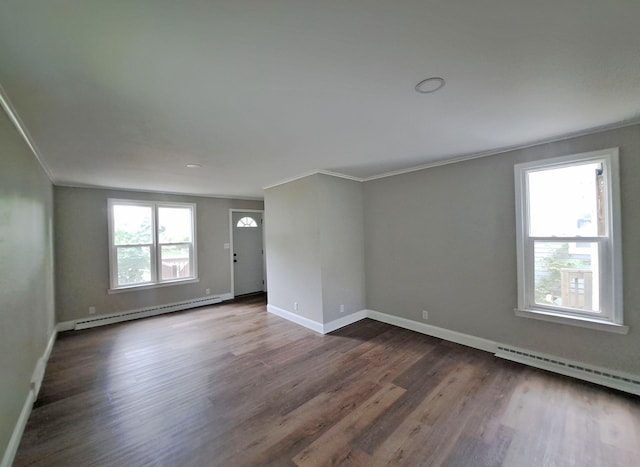 empty room featuring a baseboard heating unit, crown molding, and dark hardwood / wood-style flooring