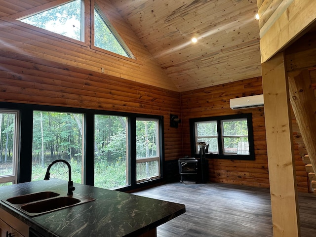 interior space featuring dark hardwood / wood-style flooring, a wood stove, a wall mounted air conditioner, sink, and high vaulted ceiling