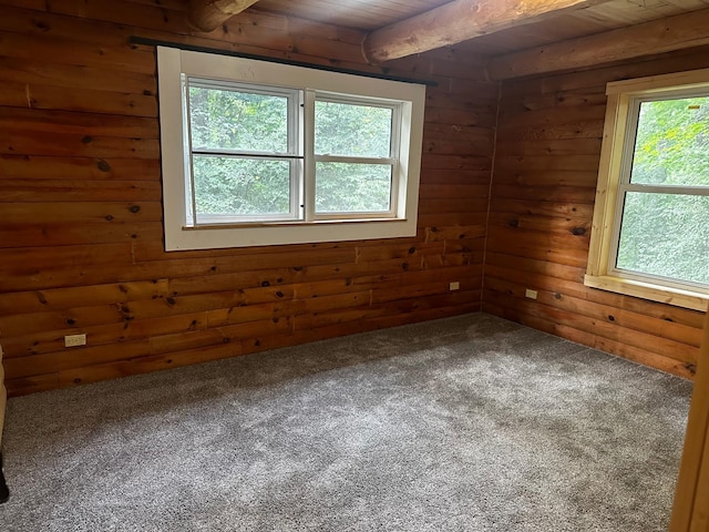 empty room with wooden ceiling, wood walls, beamed ceiling, and carpet floors