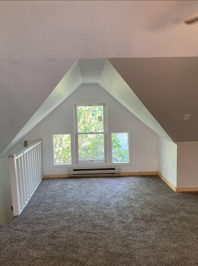 additional living space featuring a textured ceiling, lofted ceiling, carpet flooring, and a baseboard radiator