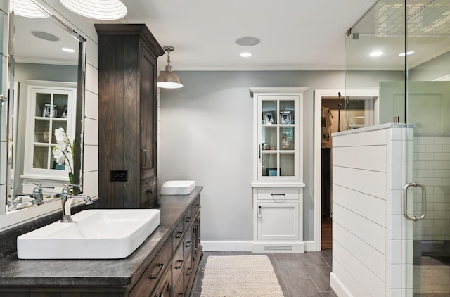 bathroom featuring ornamental molding, hardwood / wood-style flooring, vanity, and a shower with shower door