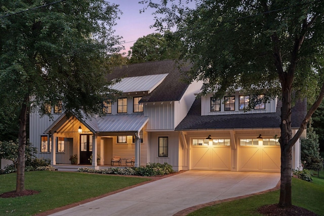 view of front of property featuring a garage, a porch, and a lawn