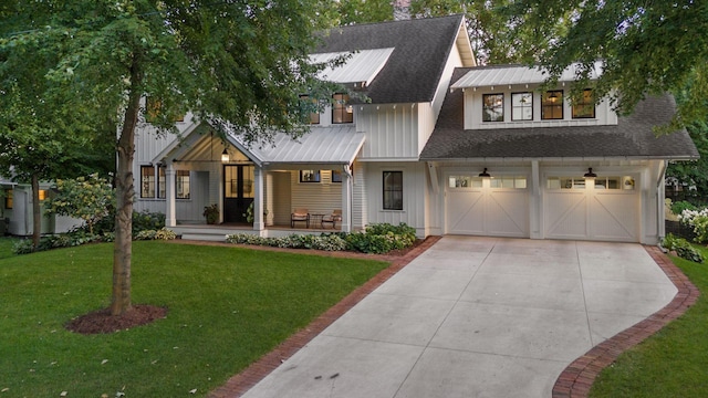 modern farmhouse with a front yard, roof with shingles, covered porch, concrete driveway, and a garage