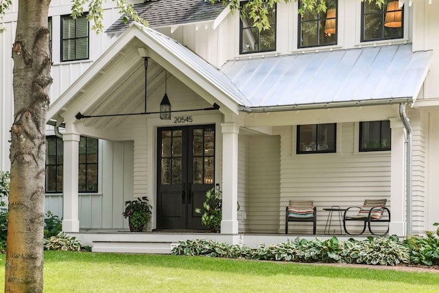 doorway to property featuring a standing seam roof, a shingled roof, french doors, board and batten siding, and metal roof