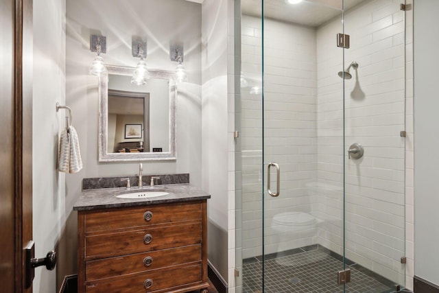 bathroom with a shower with shower door and vanity