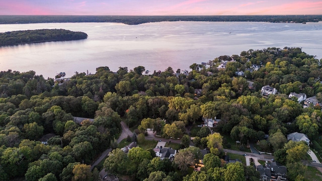 aerial view at dusk featuring a water view