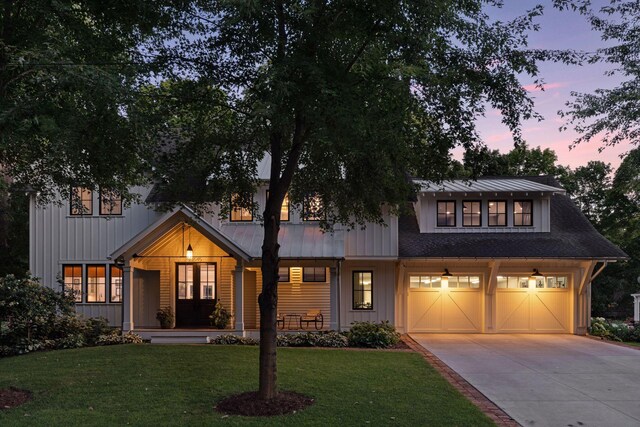 view of front of home with a front lawn, board and batten siding, an attached garage, driveway, and a porch