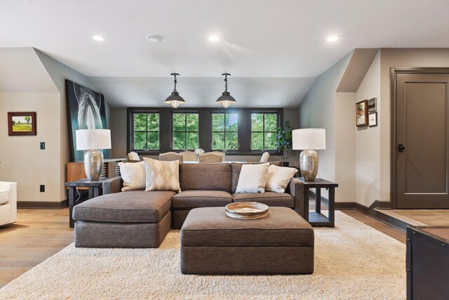 living area with recessed lighting, baseboards, lofted ceiling, and light wood-style floors