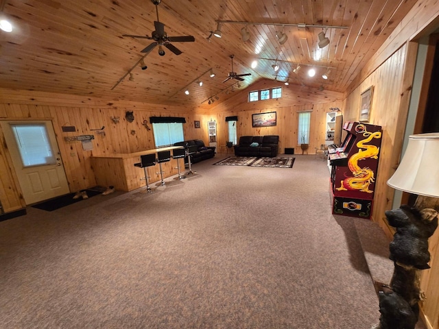 interior space with wooden walls, track lighting, wood ceiling, vaulted ceiling, and carpet flooring