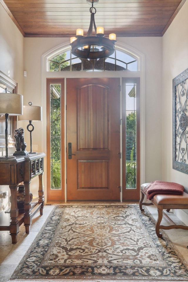 entryway featuring a chandelier, plenty of natural light, and wooden ceiling