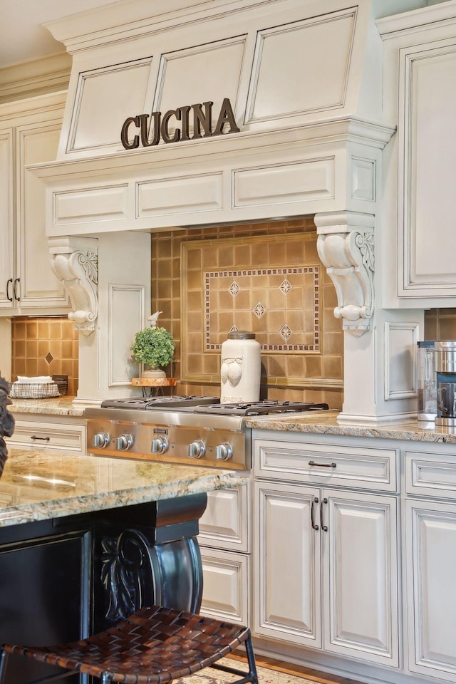 interior space featuring light stone countertops, decorative backsplash, and stainless steel gas cooktop