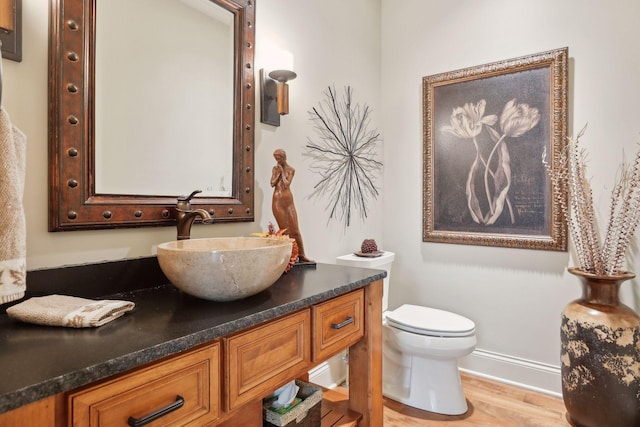 bathroom featuring hardwood / wood-style flooring, toilet, and vanity